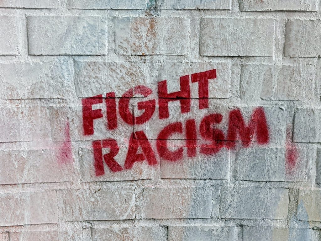 Fight Racism stamped on a brick wall