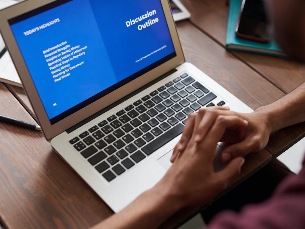 an open laptop with a person's arms resting on it
