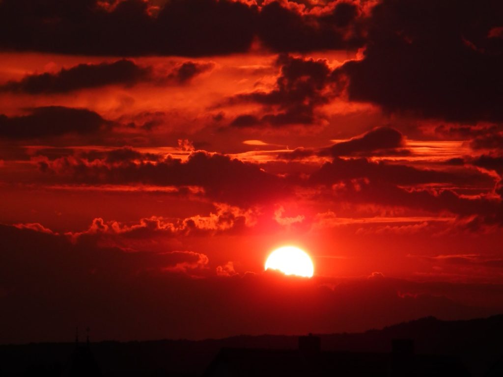 a red sky with dark clouds at sunset